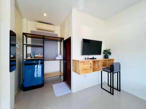 a living room with a television and a counter with a stool at เสม็ด โฮเทล Samed Hotel in Ko Samed
