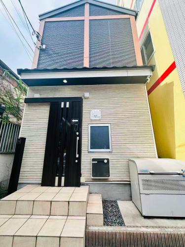 a house with a door and a television in front of it at 桜宿Sakura Yado in Yokohama