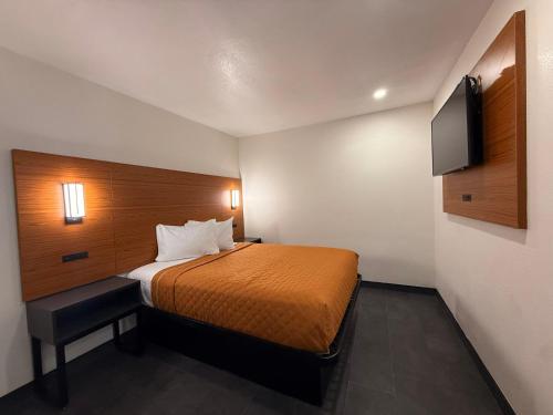 a small room with a bed and a flat screen tv at SOFI MOTEL in Los Angeles