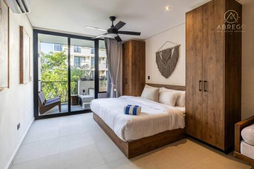 a bedroom with a large bed with a ceiling fan at Xibalba Tulum in Tulum