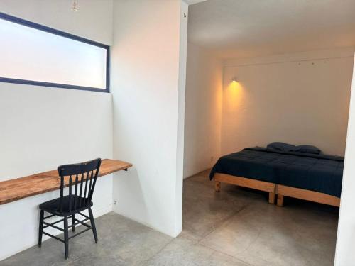 a bedroom with a bed and a desk and a chair at Casa Hoja Azul in San Miguel de Allende