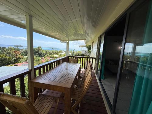 a porch with a wooden table and benches on it at Luna's Home Raiatea 