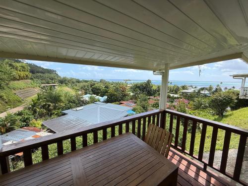 a deck with a bench and a tennis court at Luna's Home Raiatea 