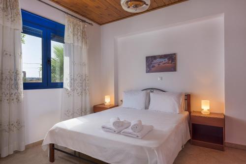 a bedroom with a white bed with towels on it at Villa Deep Blue in Lakhania