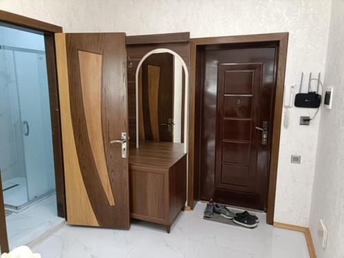 a bathroom with a wooden door and a mirror at Worldly Home in Mekhrably