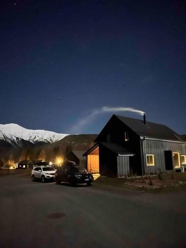 a barn at night with cars parked in a parking lot at Hot Tub and Views in Castle Hill