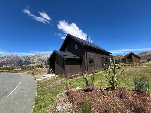 a black house sitting on the side of a road at Hot Tub and Views in Castle Hill