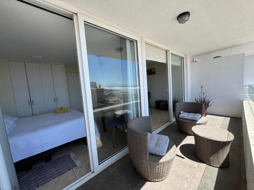 a room with a bedroom with a bed and chairs at vista al mar in La Serena