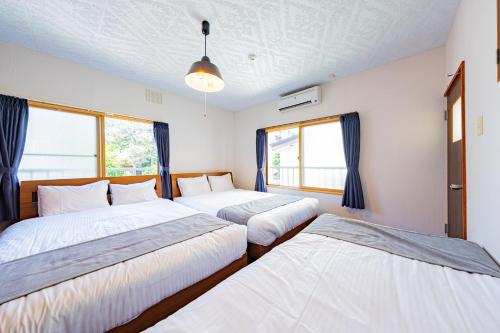 a bedroom with two beds and two windows at Extreme in Sapporo