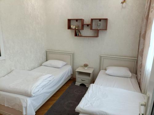 a room with two beds and a table and a mirror at Worldly Home in Mekhrably