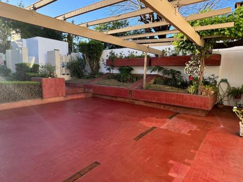 un patio con suelo de ladrillo rojo y techo en La Casona, en Alta Gracia