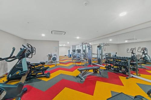 a gym with several tread machines on a colorful carpet at Luxe Sydney Olympic Park Stay - 2BR for 4 Guest in Sydney