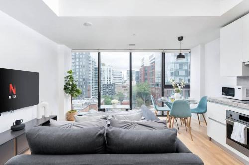 a living room with a gray couch and a dining room at Urban Oasis Condo with Cafe & Bar at Your Doorstep in Toronto