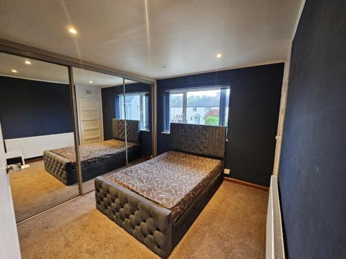 une chambre avec deux lits et une grande fenêtre dans l'établissement Home at Richmond - Conifer Crescent, à Nottingham