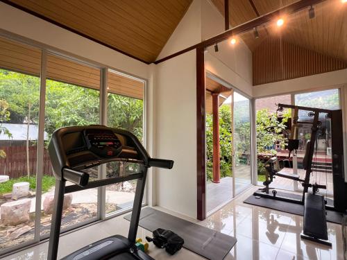 a room with a gym with a treadmill and windows at The Choice Hotel - Adults Only in Bangkok