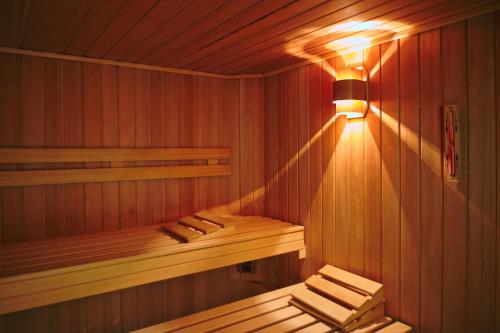 a wooden sauna with a light on the wall at GolfResort Semlin in Semlin