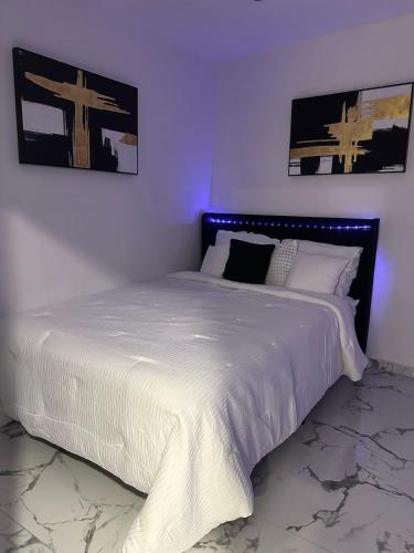 ein Schlafzimmer mit einem großen Bett mit weißer Bettwäsche in der Unterkunft 3D Bless Apartment 4 min from the airport and beach in San Juan