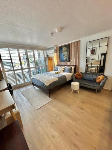 a large bedroom with a bed and a couch at West End Central Apartments in Brisbane