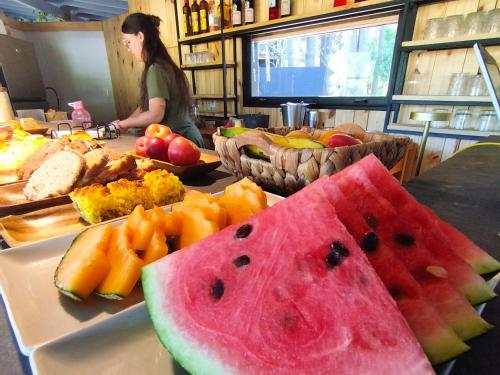 a table with a plate of watermelon and other fruits at Bosque Las Delfinas in Punta Colorada