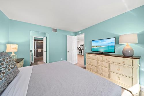 a bedroom with a bed and a flat screen tv at Sand Dollar Suite - 632A in Siesta Key