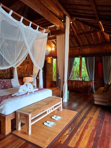 a bedroom with a bed with a canopy at Ubud Virgin Villa in Ubud
