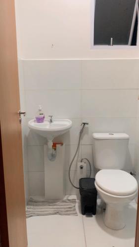 a white bathroom with a toilet and a sink at Residência da day in Aracaju