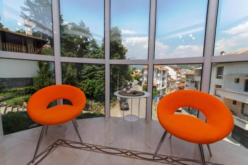 two orange chairs in a room with a large window at Sandanski Peak Guest Rooms in Sandanski