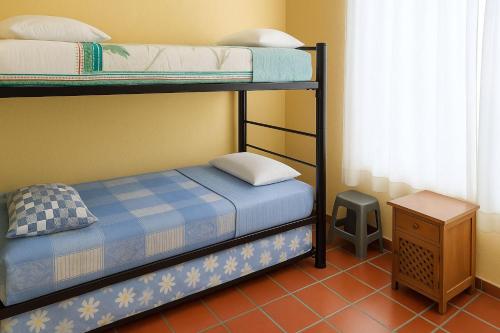 Un dormitorio con dos literas y una mesa. en Casa de Descanso Flandes, en Flandes