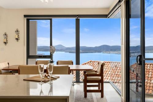 サンディ・ベイにあるThe View Luxury home 6 bed 4 bathの水辺の景色を望むダイニングルーム