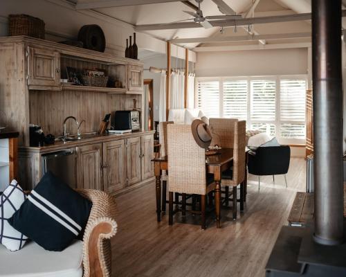 una cucina e un soggiorno con tavolo e sedie di Boathouse - Birks River Retreat a Goolwa