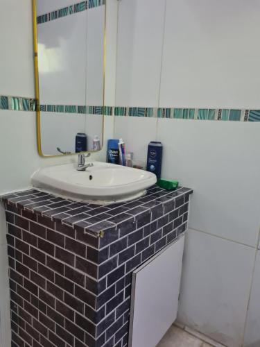 un baño con lavabo y espejo en Linstead AirB&B, en Linstead