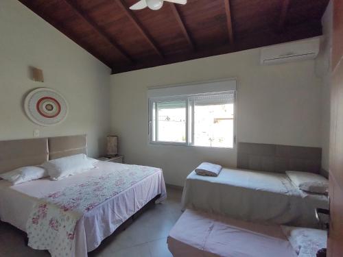 a bedroom with two beds and a window at Pousada Familiar Morada Lua Nova in Florianópolis