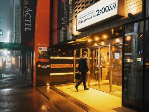 Ein Mann, der vor einem Laden die Straße entlangläuft. in der Unterkunft Hotel Actel Nagoya Nishiki in Nagoya