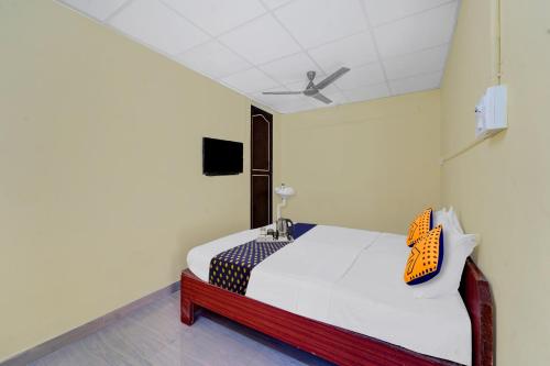 a bedroom with a bed and a tv on the wall at Hotel O KVR Residency in Chennai