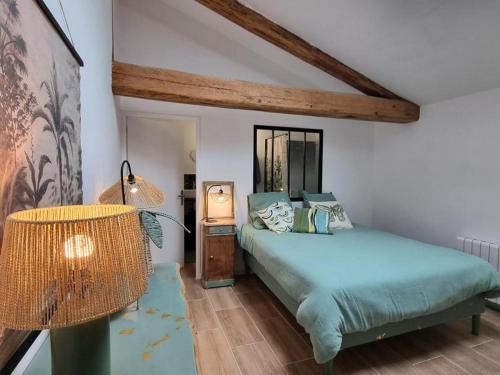 a bedroom with a bed and a lamp at Gîte de charme pour 5 pers. avec terrasse privative dans la Loire - FR-1-496-375 in Grézieux-le-Fromental