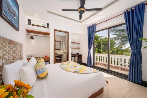 a living room with a white couch and a large window at CocoPalm Hoi An River Beach in Hoi An