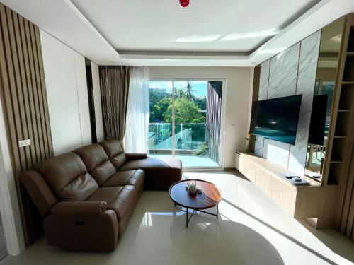 a living room with a couch and a table at Bright 2BR Condo near Central Phuket FREE Pool Gym Parking in Ban Ket Ho