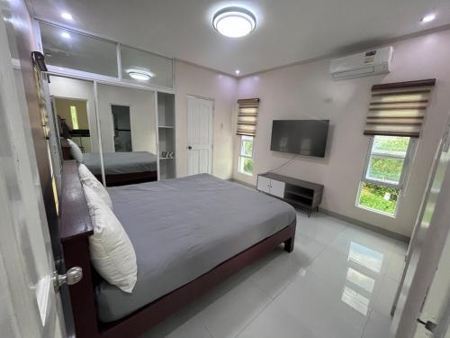 a bedroom with a large bed and a television at La Roma - Hot Spring Private Resort in Pansol