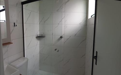 a bathroom with a shower with a glass door at Pousada Hotel Sol Nascente in Mafra