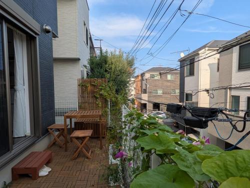 a patio with a wooden table and bench on a balcony at Han Homes Yokohama in Yokohama