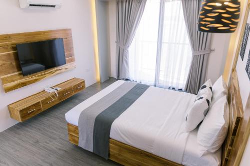 a bedroom with a large bed and a tv at Emavel Beach Resort in Balaoan