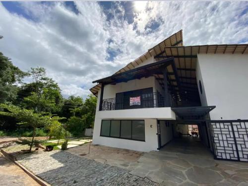 ピレノポリスにあるEsquina Da Mataのバルコニー付きの広い白い家