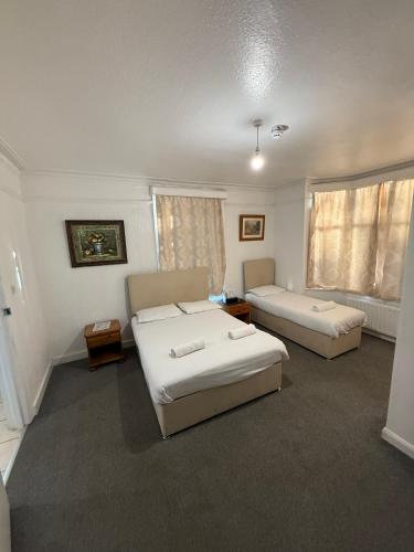 a hotel room with two beds and a couch at The Birchwood Lodge in Horley