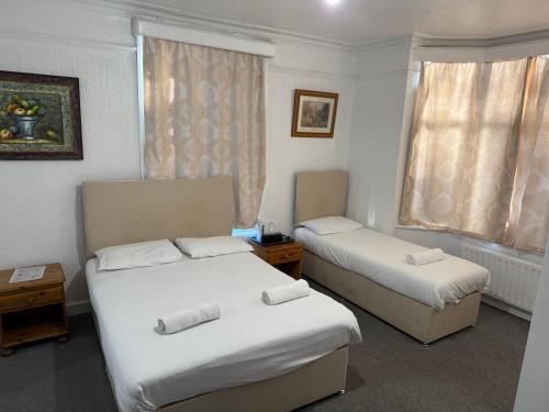 a hotel room with two beds and a window at The Birchwood Lodge in Horley