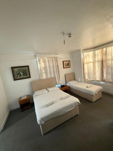 a hotel room with two beds and a couch at The Birchwood Lodge in Horley