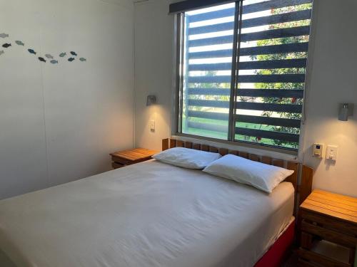 a bedroom with a bed with a large window at Orchid Oasis Orchid Beach KGari Fraser Island in K'gari Island (Fraser Island)