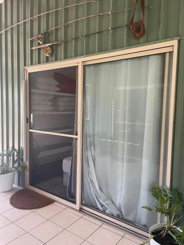 a sliding glass door to a patio with a shower at Orchid Oasis Orchid Beach KGari Fraser Island in K'gari Island (Fraser Island)
