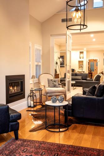 a living room with black furniture and a fireplace at 23onWindsor in Hahndorf