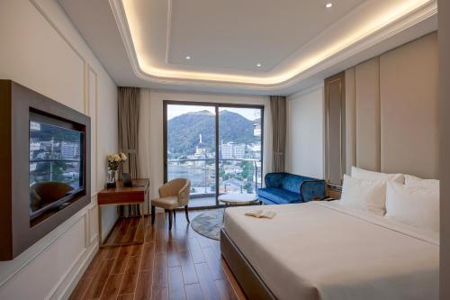 a hotel room with a bed and a large window at OYSTER BAY HOTEL VUNG TAU in Vung Tau