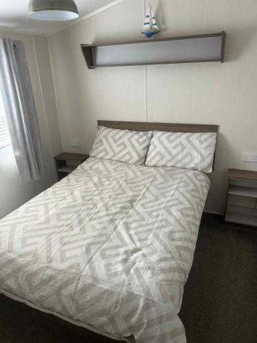 a bedroom with a bed with a white comforter at Newton Beach retreat in Porthcawl